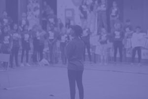 student standing in front of crowd with microphone